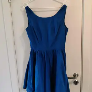 Jättefin blå klänning med knyt i ryggen. Ca fingertoppslängd på kjolen. Ger ett härligt 50-tals stuk.