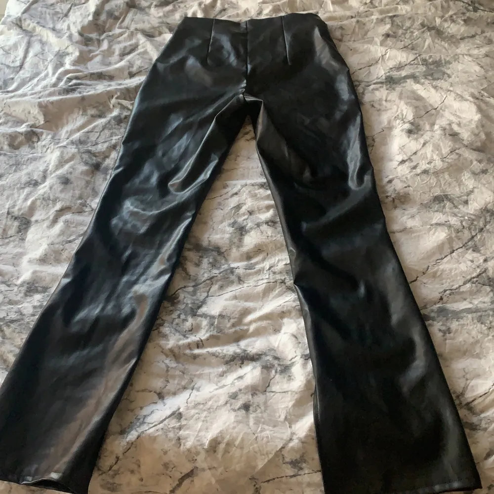 Det är ett par svarta skinbyxor med slits längst ner storlek 40 och är från h&m!. Jeans & Byxor.