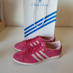 Adidas superstar sleek series strl 37  - Adidas superstar sleek series I strl 37 1/3. Ceriserosa mocka med ljust rosa sulor. Nätta och ganska smala. I använt skick. Rengjorda för hand inuti och utanpå med rengöring för sneakers och mockan är borstad, redo att användas igen! Skickar gärna fler foton! Skickas spårbart med postnord. 