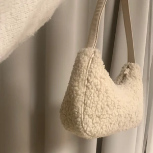 Snygg teddyväska  - Snygg och trendig teddyväska som passar perfekt över axeln. Den är i bra skick och har en kräm vit/ beige färg🤩