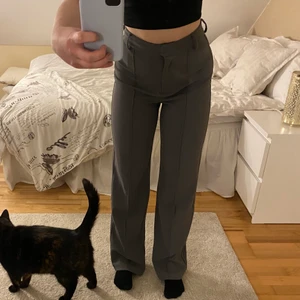 Högmidjade kostymbyxor  - Säljer dessa fina och långa kostymbyxor från NA-KD då jag knappt änvänder dom. Jag är 167cm lång och tycker dom är jättebra i längden. Funkar nog bra för ganska långa tjejer också. Knappt använda så i väldigt bra skick.