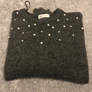 Hej säljer en tröja då den är för liten  - Hej säljer en tröja från H&M då den är för liten den är grå och stickad dina pärlor på framsidan den är ganska stor i storleken
