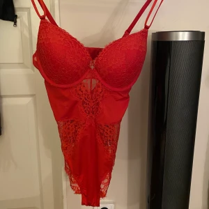 Röd body från H&M - En röd body från H&M. Den är i fint skick, och är använd typ 2/5 gånger. Storlek M/L.  