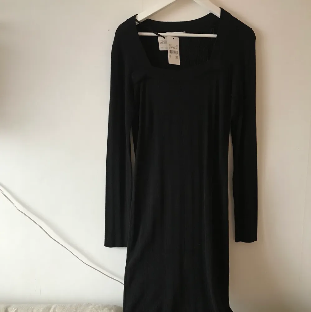 Vacker svart klännig med fin textur och fyrkantig krage. Oanvänd!. Klänningar.