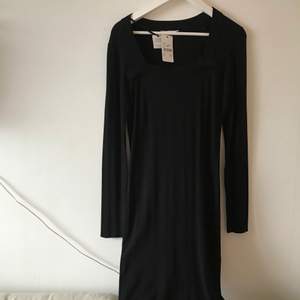 Vacker svart klännig med fin textur och fyrkantig krage. Oanvänd!