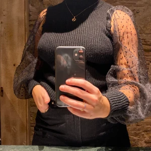 Svart stickad tröja med organza-ärmar - Jättefin svart stickad tröja med ärmar i organza med små prickar på. Köptes i en liten butik i Barcelona och saknar därmed tagg, Strl S