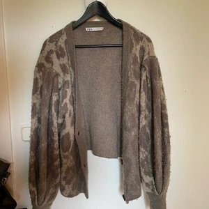 Kofta  - Brun kofta. En knapp saknas men det syns eller märks inte