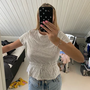 Prickig t-shirt - Vit svart prickig t-shirt från zara med knyte och resor i midjan🤍 använd några gånger, storlek L men sitter som en S. 50kr+frakt🤍🤍