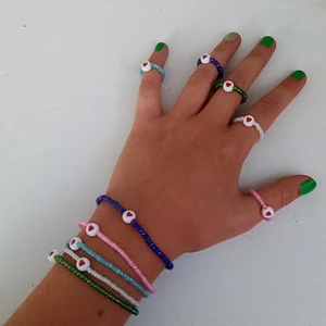 Armband och ringar - det är lite olika mått på allt men de är gjort av elastisk tråd, de är nytt och hemmagjort ochfrakten står på 11 kr. Ett armband kostar 13 kr och en ring 5 kr.