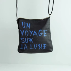 La Lune🌙 by M.E.J UF - Rymlig väska med justerbar axelrem. Två ganska stora fickor med dragkedja där bak. Färgen är sprejad med skyddslack så den håller för en del vatten. 220kr + frakt, vide flera intresserade sker budgivning. 