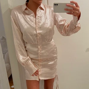 Cocktailklänning - SIDNEY SHIRT DRESS i färgen sandshell. Den har en insydd midja med veckdetaljer. Jag är 164 lång och klänningen är i storlek EU34 Aldrig använd!  