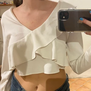 Vit blus med volang detaljer och öppen rygg  - En vit croppd blus med en jättesnygg öppen rygg. Köpt från Zara utomlands.