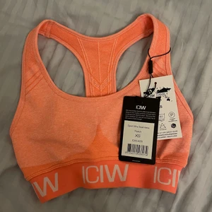 Sporttopp/bh från icaniwill (ICIW) - En jättefin sporttopp/bh helt oanvånd från ICIW. Toppen kvalite, sälja endast pga att storleken var fel 🧡💗 Peach färgad och storlek xs. (Lappen sitter kvar).