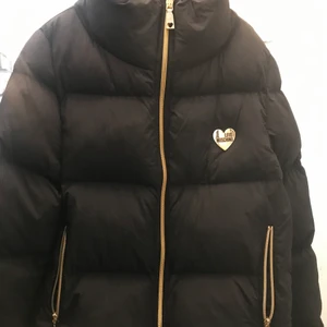 Jacka från Love Moschino i nyskick  - Supersnygg jacka från Love Moschino som inte blivit använd mer några få gånger. Svart med detaljer i guld. Stl 36-38. Perfekt höst och vinterjacka! Kvitto och orginal-galge finns. Nypris 2.200:- 