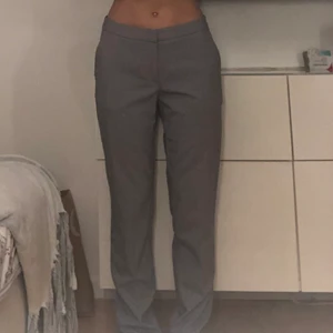 Lågmidjade Kostymbyxor  - Gråa lågmidjade kostymbyxor, innerbenslängden är 75 cm, midjemått är 78 cm