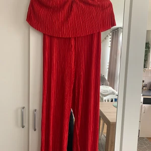 Röd byxdress  - En otroligt fin röd off shoulder byxdress i Storlek XS/S