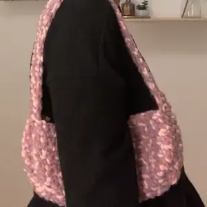 En handgjord virkad shoulderbag men rosa och lila mönster. Den är aldrig använd och väldigt unik. Jag står för frakten så om ni är intresserade är det bara att skriva till mig. Självaste väskan är 27x13 cm lång.