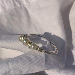 Handgjord ring med offwhite pärlor, och silverpläterad koppartråd.  Storlek: 16mm, 17mm, 19mm (Innerdiametern på ringen)