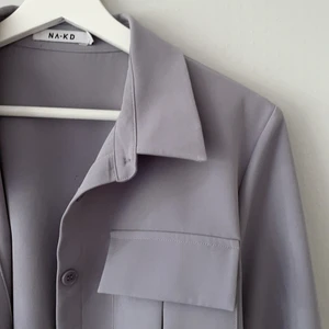 Skjorta, NAKD - En lavendellila skjorta från NAKD i storlek 40. Den har två bröstfickor och går att knäppa upp i ärmarna. Den är ganska stor i storleken, så den sitter oversized på nån med just strl 40. Skjortan är använd ca 5 gånger och har inga defekter. Köparen står för frakt och returneras ej💜