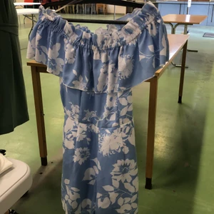Blå Playsuit med vita blommdetaljer i storlek 34 - En super gullig playsuit från New yorker i storlek S, plagget är i ett mycket gott skick och passar perfekt till sommaren