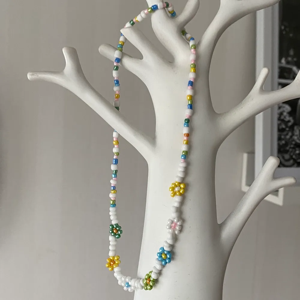 Ett handgjort färgglatt halsband med blommor gjort av seedbeads 🧡💛💜. Accessoarer.
