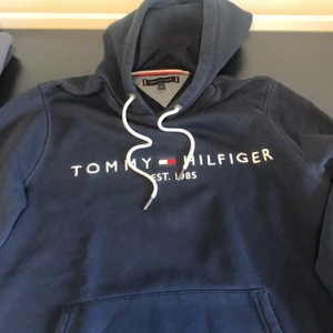 Mörkblå Tommy Hilfiger Hoodie, M - Hoodien ser svart ut på bilen men är egentligen mörkblå, väl använd, storlek M