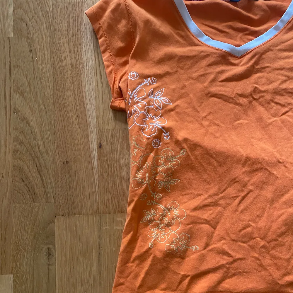 Orange T-shirt med blommor på från stadsmissionen!. T-shirts.