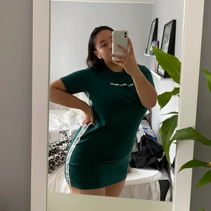 H&M grön klänning med motiv Storlek 38 - Grön t-shirtklänning från H&M med vita motiv. Använd max 3 gånger. Den är egentligen oversized men jag bär den i en mindre storlek för jag gillar hur det ser ut. Jag bär vanligtvis storlek L/XL på klänningar och är 172 cm lång.