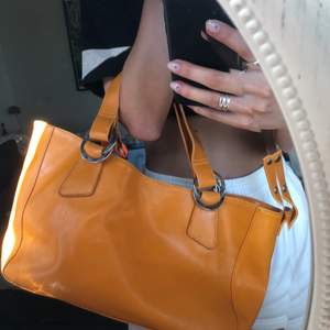 Orange stor väska, har svarta märken under som varit sedan jag köpte den second hand. Tänkte vem kollar under en väska :)