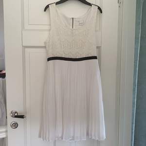 A knee long, white dress with a black strap. Both casual and pretty. Size S. 