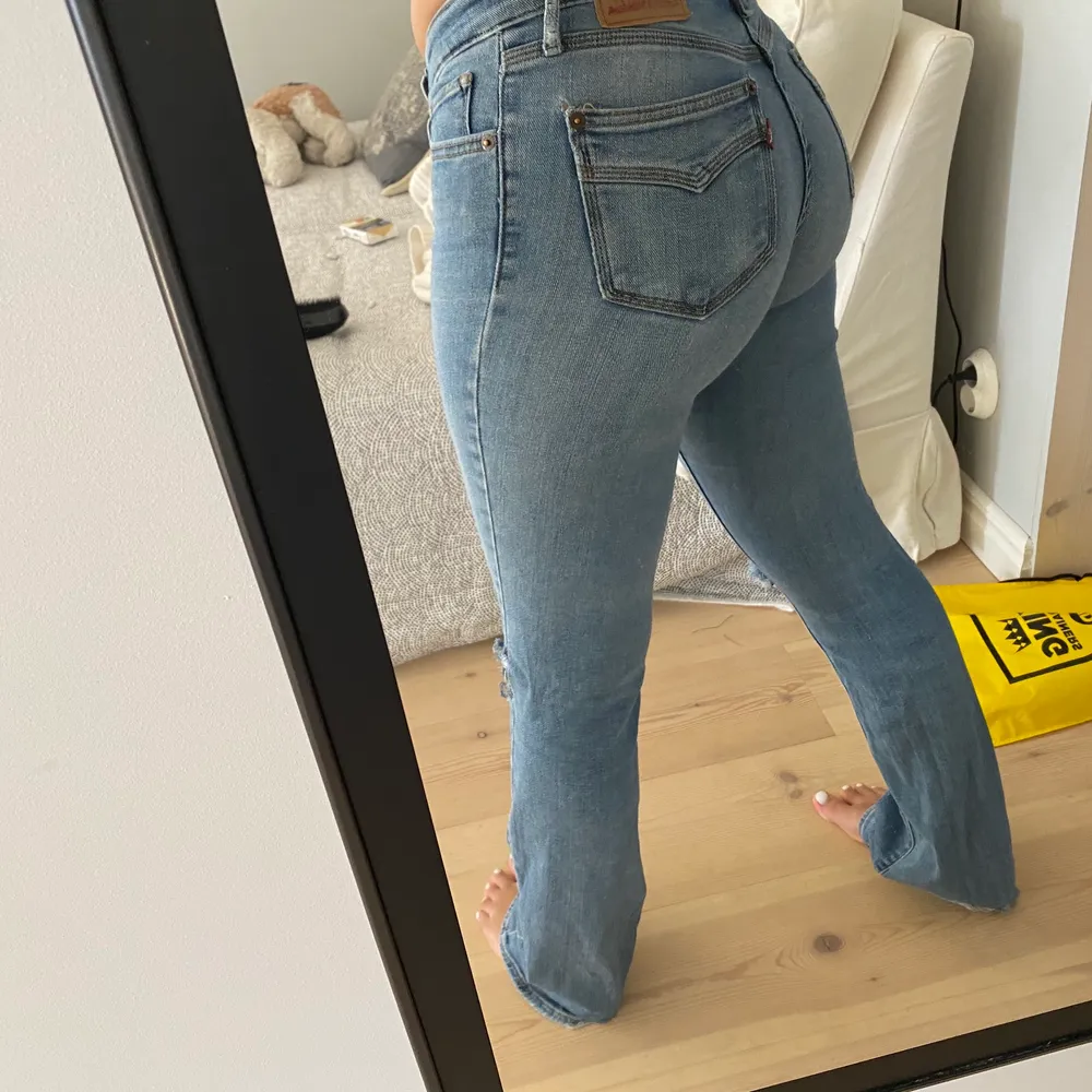 Snygga lågmidjade Levis jeans i modelen 715 bootcut. Använda väll men sitter forfarande som en smäck. Egna gjorda hål och slitna ner till som gör det till en stor detalj. Köpa för 700-800kr säljer för 200 kr eller högre bud. Jag själv har 36/38 i byxor och de sitter bra väldigt skönt material så de blir stretchiga.. Jeans & Byxor.