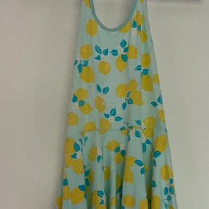 POLARN O. PYRET klänning  - Jättefin Polarn O. Pyret klänning med citroner. Inhandlad för ca 2 år sedan men endast använd ca 5 gånger så i nyskick! Klänningen är en halterneck med låg rygg, sitter tajtare uppe med en ”snurr kjol”. Den är i storlek 134-140 men passar mig som är en XS/liten S, tyget är väldigt stretchigt!                                                                 KÖPAREN STÅR FÖR FRAKT: 45 kr ej spårbart (men går att få spårbart då 66 kr).
