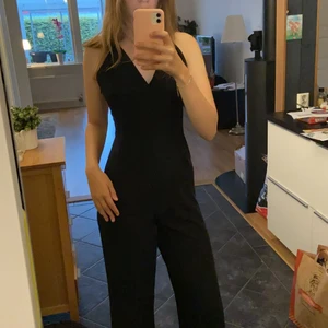 Svart jumpsuit stl S - Lång svart jumpsuit i storlek S till salu! Den är relativt pösig i passformen men smalnar av vid midja/bröst. Passar till exempel perfekt till nyår eller andra firanden. 