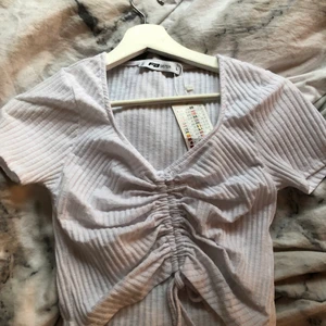 Super fin topp med justerbart band - Super fin topp med justerbar band! Aldrig använd med lappen på. Köpt från new Yorker. Storlek L sitter som en S