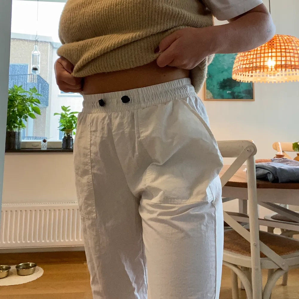 Coola vita byxor i prasselmaterial. I storlek L men sitter bra på mig som i vanliga fall har S/M.  Älskar detaljerna på byxorna med dem stora fickorna och svarta detaljer i linningarna. En bonus är att dem är sååå sköna!. Jeans & Byxor.
