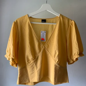 Gul topp - Aldrig använd, lappen kvar. Är en storlek XL men jag är en S vanligtvis och tyckte den satt ok, skulle rekommendera om du är en M-L :)                                                               Samfraktar gärna om du blir intresserad av något annat på min sida ;)