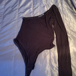 Prettylittlething topp - Svart one sleeve bodysuit från prettylittlething i storlek uk 6. Bra skick!