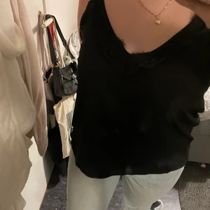 Linné med typ spets  - Fint svart linne med om jag ska vara ärlig lite konstigt spets men man skulle kunna ta bort det så skulle det vara väldigt fint, den har typ resår därbak och justerbara band