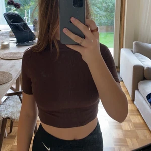 Brun croppad t shirt  - Tröjan sitter inte för tajt men inte för löst, den är croppad och har en liten krage vid halsen. Matrialet är väldigt skönt.