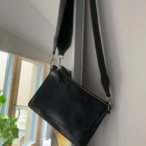 Carin Wester väska - En svart liten väska från Carin Wester med tjockare band som är en perfket detalj men går även att bytas ut till annat band. Liten men i nyskick och kommer tyvärr inte till användning längre.