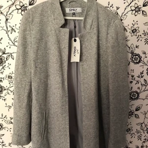 Grå kappa - Grå kappa från ONLY. Oanvänd med prislapp. Storlek 40 men passar en 38 & mindre för oversized look. Nypris 459, kom med pris förslag.