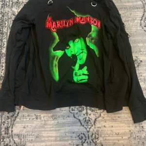 Cool Marilyn Manson hoodie, relativt använd men inga kosmetiska skador. En oversized small hoodie, medföljer även coola avtagbara straps som man lätt kan ta på och av. Nypris 700kr på Killstar. Går att mötas upp i Stockholm eller så betalar köparen för frakten.