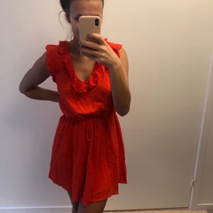 Röd/orange sommarklänning  - En jättesöt klänning med knytband i midjan, knytning bak i ryggen/nacken i en orange/röd färg. Från river island, storlek S i bra skick.