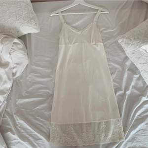 En vit medel lång klänning med spets där nere. En kort spets klänning. En rosa lång klänning med volanger. Alla sitter som storlek S