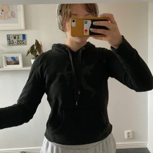 Svart huvtröja  - Svart huvtröja med tryck. Storlek XS men S funkar också beroende på hur man vill att den ska sitta. För mer info är det bara att fråga