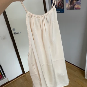 Topp - Snygg beige/rosé silkes topp , står storlek L men passar mig bra som har S. Man kan spänna åt toppen i nacken om man vill!