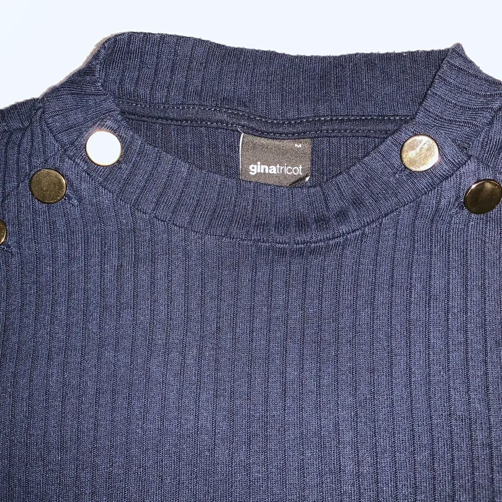 Dark blue sweater with gold buttons.. Stickat.