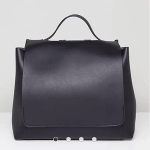 Minimalistisk ryggsäck (Läderimitation) - Väldigt rymlig. Justerbara band. Mått:  B: 36 cm H: 28 cm D: 14 cm Remlängd: 80 cm.  Beläggning: 100 % polyvinylklorid, foder: 50 % bomull, 50 % viskos, yttermaterial: 100 % polyester. Rengörs enkelt med fuktig trasa.