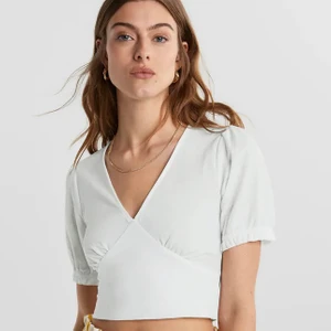Topp, Gina Tricot, xs - Topp med v ringning och puffärmar, sitter tajt runt midjan. Köptes på Gina tricot i somras, använd 2-3 gånger. Första två bilderna lånade, säljer pga kommer ej till användning✨
