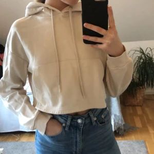 Croppad hoodie - Beige croppad hoodie i storlek xs. Har använt den ett fåtal gånger så den är som ny. Från bershka